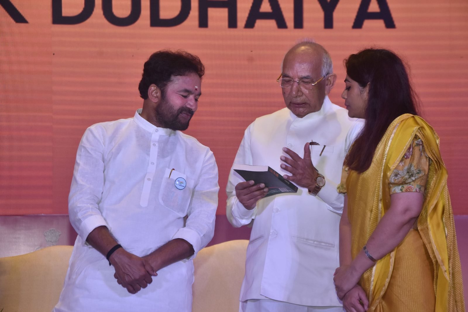 A book being presented and read on stage at Chitranjali