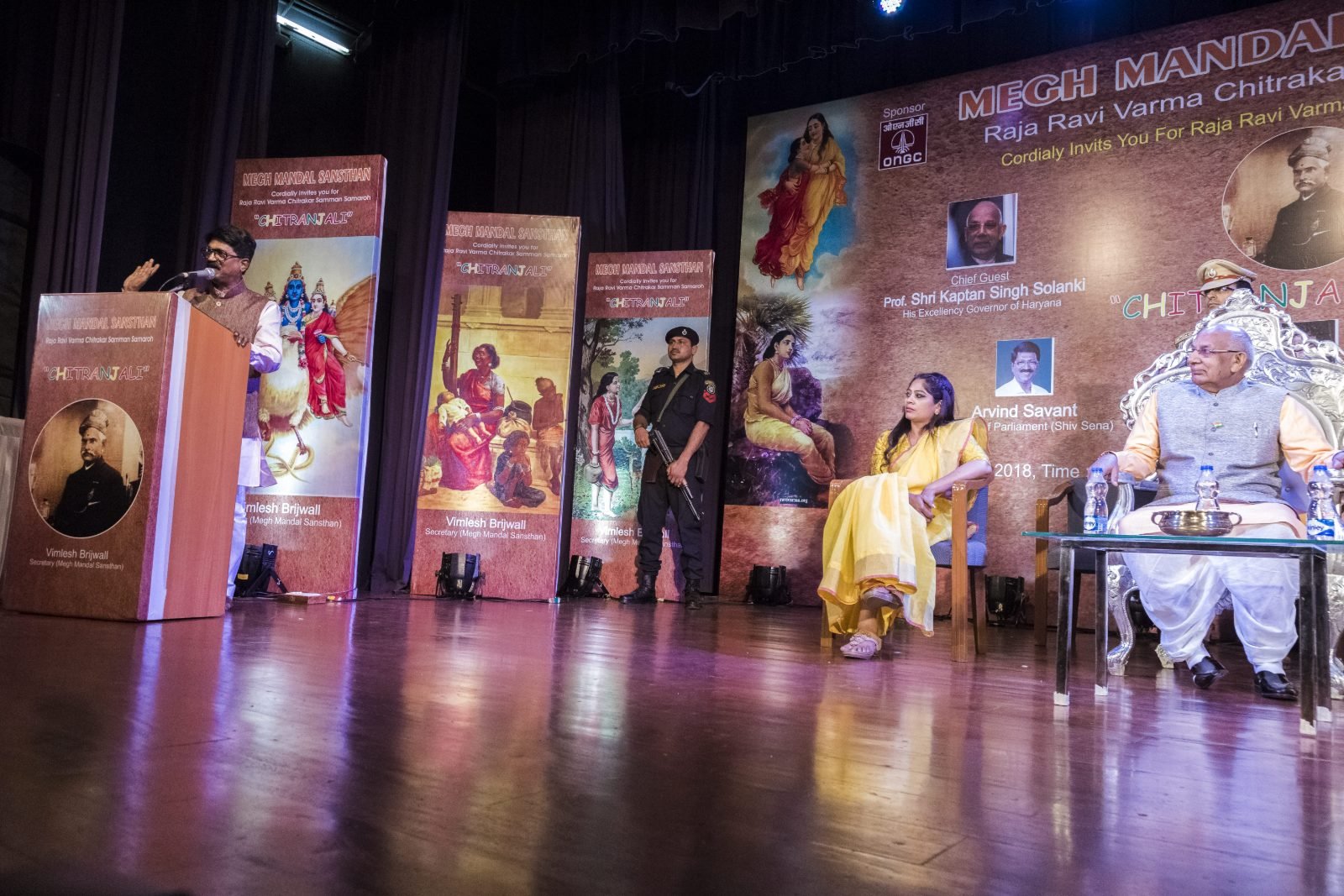 Address from the podium at Chitranjali, with Raja Ravi Varma paintings on the backdrop