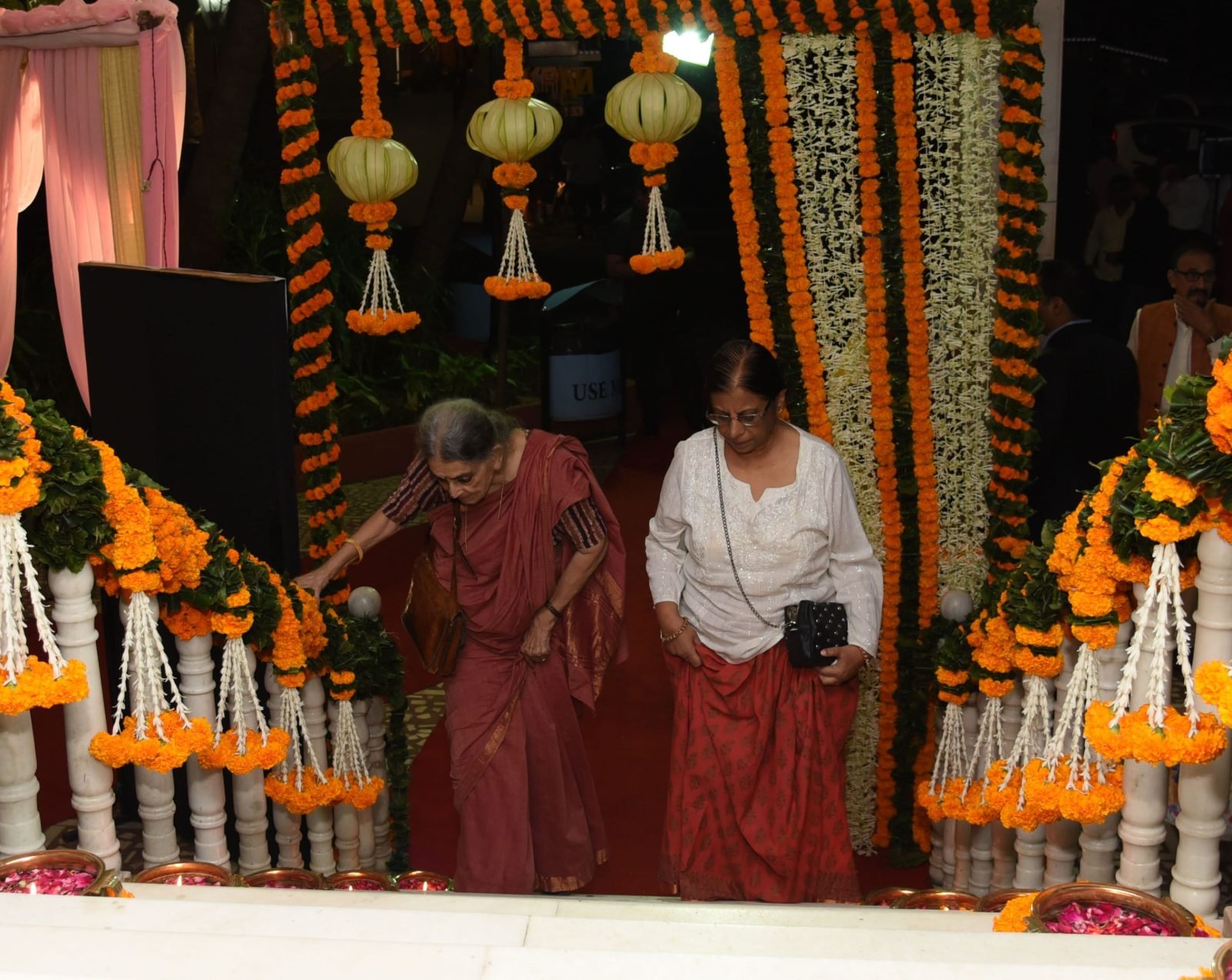 Guests arriving past lit diyas at the decorated entrance