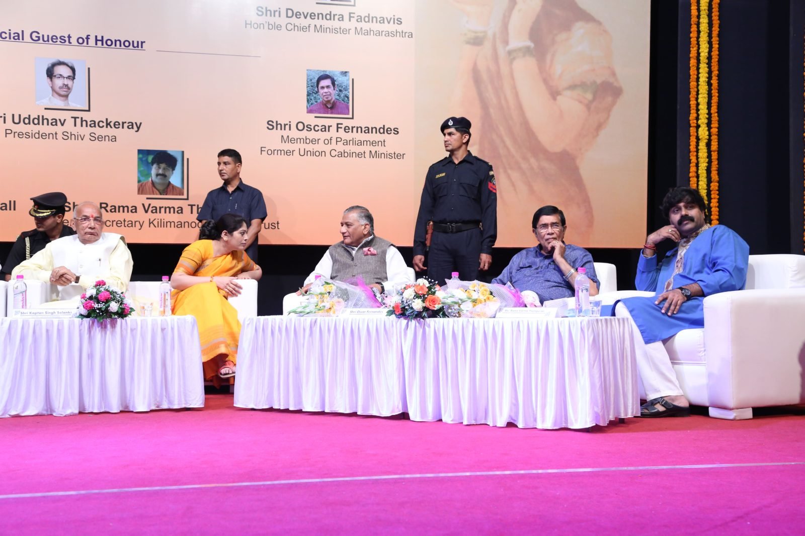 Guests of honour lighting the ceremonial lamp beside a garlanded painting at Chitranjali 2016