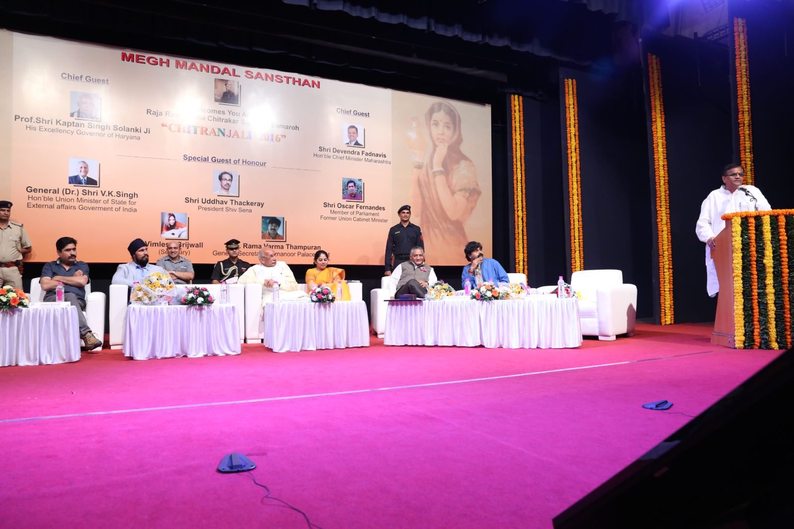 A guest speaking from the podium with the dais alongside at Chitranjali 2016