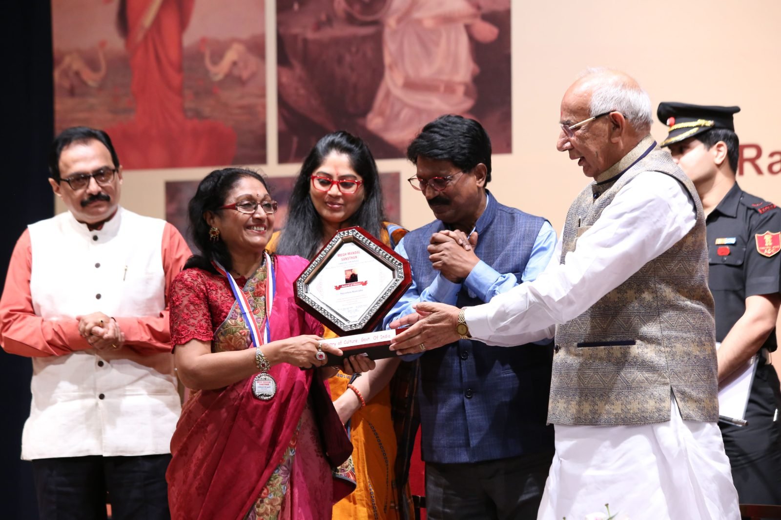 Secretary Vimlesh Brijwall seated on stage with a guest of honour